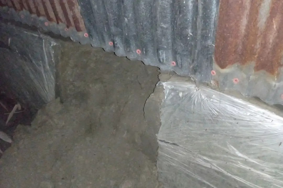 Distressed villagers of Phulbari's Rabaitary commune stand together in the dark, illuminated by flashlights and moonlight, pointing towards a dug-out hole where robberies occurred, amidst suspicions of poisonous gas use to incapacitate residents.